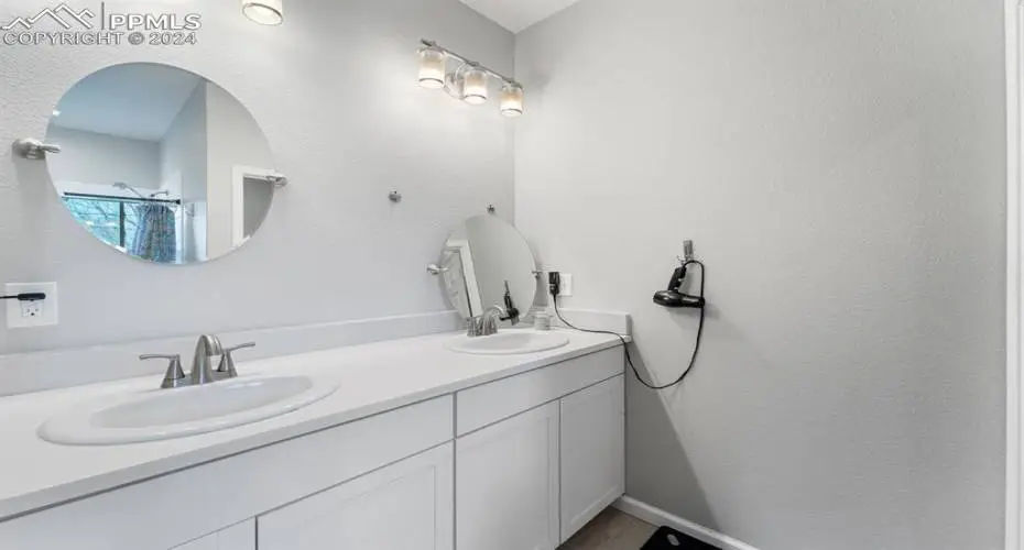 Bathroom with double sink and vanity with extensive cabinet space